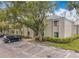 Condo building exterior showcasing parking, mature trees, and tidy green landscaping at 163 Springwood Cir # D, Longwood, FL 32750