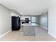Bright kitchen featuring white cabinets, black appliances, mosaic backsplash and an island with a light granite countertop at 163 Springwood Cir # D, Longwood, FL 32750