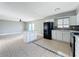 Kitchen featuring white cabinets, black appliances, mosaic backsplash and island at 163 Springwood Cir # D, Longwood, FL 32750