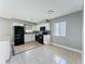 Kitchen featuring white cabinets, black appliances, mosaic backsplash and neutral tile flooring at 163 Springwood Cir # D, Longwood, FL 32750