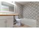 Bathroom showcasing decorative tile work, a white vanity, and a combination tub and shower at 1714 Golfview Dr, Kissimmee, FL 34746