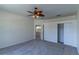 Large bedroom features neutral walls and carpet, ceiling fan, closet, and door to another room at 1714 Golfview Dr, Kissimmee, FL 34746