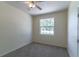 Comfortable bedroom with neutral decor, carpet, and ceiling fan, featuring a window overlooking the landscape at 1714 Golfview Dr, Kissimmee, FL 34746