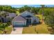 Charming single-Gathering home featuring a well-manicured lawn, lush landscaping, and an attached two-car garage at 1714 Golfview Dr, Kissimmee, FL 34746