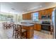 Well-lit kitchen featuring wooden cabinetry, stainless steel appliances, granite countertops, and an island at 1714 Golfview Dr, Kissimmee, FL 34746