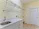 Convenient laundry room with ample counter space, a utility sink, and a wire shelving rack at 1714 Golfview Dr, Kissimmee, FL 34746
