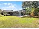 Expansive backyard features a screened-in pool, lush lawn, and mature trees at 2003 Woodcrest Dr, Winter Park, FL 32792