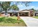 Charming single-story home with brick accents, a well-manicured lawn, and an inviting carport at 2003 Woodcrest Dr, Winter Park, FL 32792