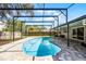 Beautiful kidney-shaped pool is surrounded by a screened-in enclosure and brick paver deck at 2003 Woodcrest Dr, Winter Park, FL 32792