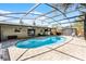 A gorgeous screened-in pool with lounge seating, outdoor kitchen, and private backyard at 2003 Woodcrest Dr, Winter Park, FL 32792