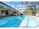 Inviting screened-in pool with lounge seating, an outdoor kitchen, and a private backyard at 2003 Woodcrest Dr, Winter Park, FL 32792