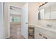 Bathroom featuring a vanity area with a stool, a bright mirror, and an open doorway to the bedroom at 2007 Cornell Pl # 4, Port Orange, FL 32128