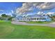 Beautiful clubhouse featuring well manicured landscaping and a brick driveway under a cloudy, blue sky at 2007 Cornell Pl # 4, Port Orange, FL 32128