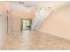 Open living room boasts tile flooring, staircase, sliding glass door, and modern light fixture at 2007 Cornell Pl # 4, Port Orange, FL 32128