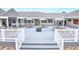 Relaxing outdoor patio with multiple tables and chairs, umbrellas, and a fire pit with stairs leading to the patio at 2007 Cornell Pl # 4, Port Orange, FL 32128
