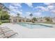 Community pool area with a covered patio and lounge chairs under a sunny, partly cloudy sky at 2007 Cornell Pl # 4, Port Orange, FL 32128