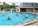 People enjoying a swimming pool with an instructor in the background, surrounded by lush landscaping at 2007 Cornell Pl # 4, Port Orange, FL 32128