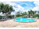 Inviting community pool with lounge chairs and umbrellas surrounded by lush landscaping on a sunny day at 2007 Cornell Pl # 4, Port Orange, FL 32128