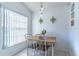 Bright dining area with a wood table, white chairs, natural light, and decorative wall art at 3109 Bear Path, Kissimmee, FL 34746