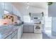 Bright kitchen featuring gray cabinets, white appliances, marble-look countertops, and plenty of natural light at 3109 Bear Path, Kissimmee, FL 34746