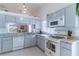 Light, airy kitchen featuring modern white appliances, marbled counters, and ample cabinet space at 3109 Bear Path, Kissimmee, FL 34746