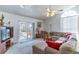 Bright living room with sliding glass doors to the lanai, a comfortable couch, and a ceiling fan at 3109 Bear Path, Kissimmee, FL 34746