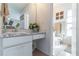 Well-lit bathroom with a clean white vanity, marble countertop, and toilet with tiled floors at 3109 Bear Path, Kissimmee, FL 34746