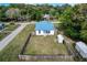 Charming home with a blue roof, surrounded by a spacious fenced yard and lush greenery at 3512 Central Ave, Coleman, FL 33521