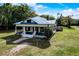 Aerial view of the charming home with metal roof, front porch, and lush green lawn at 3512 Central Ave, Coleman, FL 33521