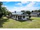 Charming home featuring a covered front porch, white siding, black window trim, and a beautifully landscaped lawn at 3512 Central Ave, Coleman, FL 33521
