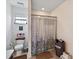 View of a well-lit bathroom with a shower, toilet, and convenient storage basket above the toilet at 3528 Seneca Club Loop # 103 - C, Orlando, FL 32808