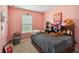 Comfortable bedroom with a pink wall and a cozy bed at 3528 Seneca Club Loop # 103 - C, Orlando, FL 32808