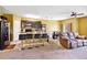 Open-concept living room with carpeted floor, ceiling fan, and bar stool kitchen seating at 3528 Seneca Club Loop # 103 - C, Orlando, FL 32808