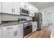 Bright kitchen features stainless steel appliances, white cabinetry, and granite countertops at 411 St Johns Ln, Kissimmee, FL 34759