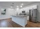 Kitchen island with pendant lighting, stainless steel refrigerator, and white cabinets at 411 St Johns Ln, Kissimmee, FL 34759