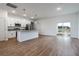 Open-concept living area with wood flooring, a kitchen view, and sliding glass doors to the yard at 411 St Johns Ln, Kissimmee, FL 34759