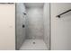 Walk-in shower with white marble tile and black fixtures at 411 St Johns Ln, Kissimmee, FL 34759