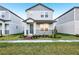 Charming two-story home with gray siding, landscaped yard and cozy front porch at 4673 Cross Prairie Pkwy, St Cloud, FL 34772