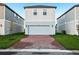 Two-story home features a brick driveway and a two-car garage with an attached manicured lawn at 4673 Cross Prairie Pkwy, St Cloud, FL 34772