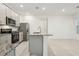 Open kitchen with island, stainless steel appliances, and white walls at 4673 Cross Prairie Pkwy, St Cloud, FL 34772