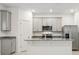 Bright kitchen with stainless steel refrigerator, granite countertops, gray cabinetry, and modern appliances at 4673 Cross Prairie Pkwy, St Cloud, FL 34772