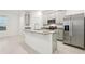 Modern kitchen featuring granite countertops, an island, stainless steel appliances, and stylish gray cabinets at 4673 Cross Prairie Pkwy, St Cloud, FL 34772