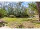 Scenic backyard view with a peaceful pond surrounded by trees and a well-maintained lawn at 4828 Pebble Beach Dr # A, Orlando, FL 32811