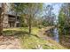 View of the backyard and creek, with green grass and trees at 4828 Pebble Beach Dr # A, Orlando, FL 32811