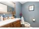 Bathroom features a wood vanity with white sink, toilet, and blue wall paint at 4828 Pebble Beach Dr # A, Orlando, FL 32811
