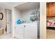Laundry room area with white washer and dryer, and storage shelves at 4828 Pebble Beach Dr # A, Orlando, FL 32811