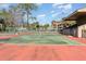 Active lifestyle enhanced by tennis court with green and red surface, netted center, and lush green surroundings at 4828 Pebble Beach Dr # A, Orlando, FL 32811