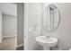 Modern bathroom features a pedestal sink and a round mirror at 5093 Railroad Vine Aly, Winter Garden, FL 34787