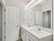 Bright bathroom featuring a double sink vanity with quartz countertop, ample lighting, and door at 5093 Railroad Vine Aly, Winter Garden, FL 34787