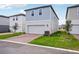 Charming two-story home with light blue siding, a two-car garage, and a well-manicured lawn at 5093 Railroad Vine Aly, Winter Garden, FL 34787